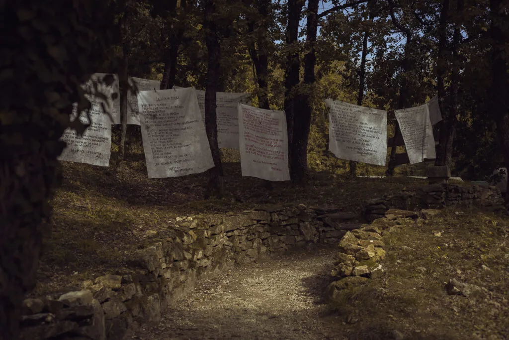 Textes suspendus sur des draps dans les bois de Port-d’Envaux
